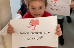 Crianças do Turno Integral comemoram o Dia do Abraço levando carinho pelos corredores da instituição